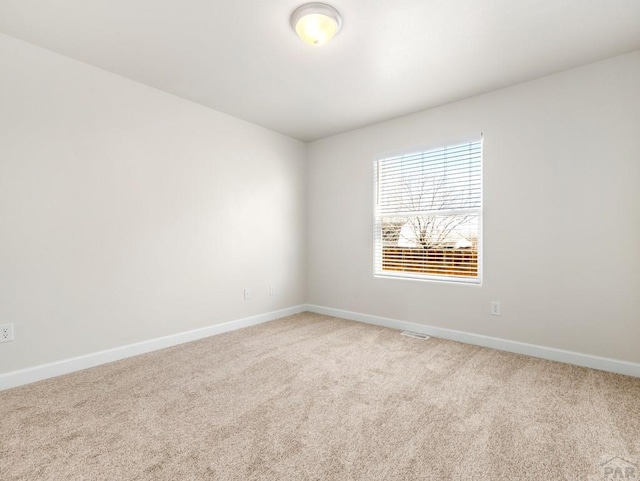 carpeted spare room with baseboards