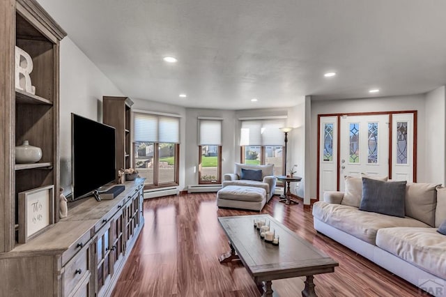 living area with a baseboard heating unit, recessed lighting, baseboards, and wood finished floors