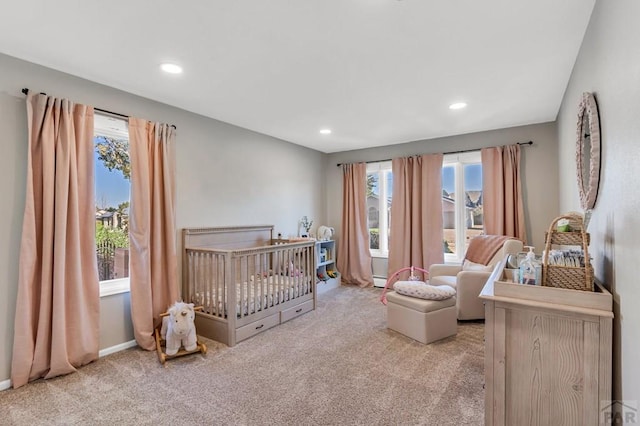 bedroom featuring recessed lighting, light carpet, a crib, and baseboards