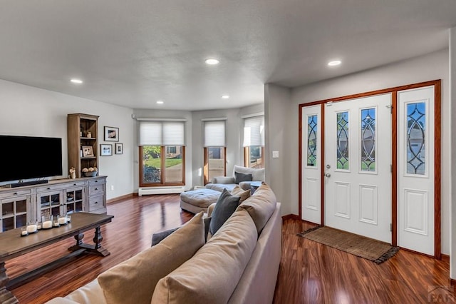 living area with a baseboard heating unit, recessed lighting, dark wood-style flooring, and baseboards