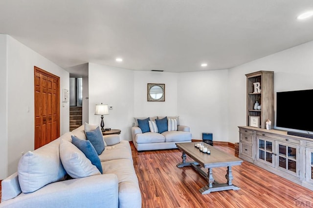 living room with visible vents, stairway, wood finished floors, and recessed lighting