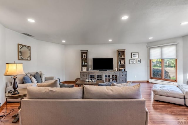 living room featuring baseboards, visible vents, wood finished floors, baseboard heating, and recessed lighting