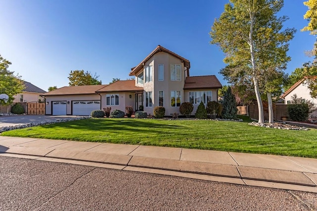 view of front of property with a garage, driveway, a front yard, and fence