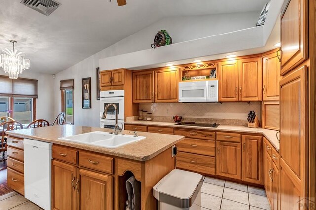 kitchen featuring white appliances, a center island with sink, brown cabinets, light countertops, and pendant lighting