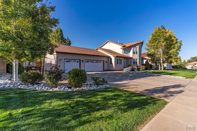 view of front of home with a tile roof, stucco siding, concrete driveway, an attached garage, and a front yard