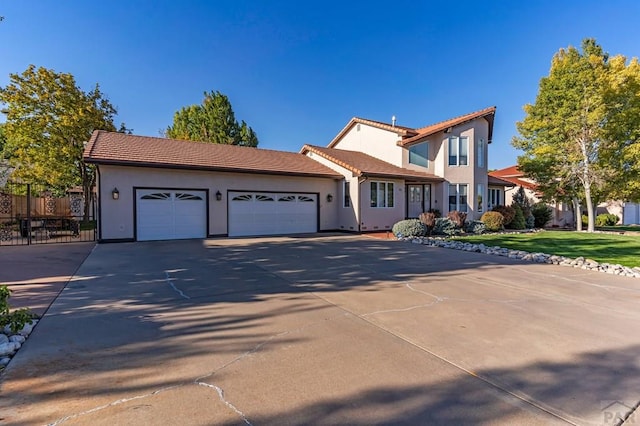 view of front of home featuring concrete driveway, a tiled roof, an attached garage, fence, and stucco siding