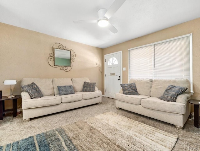 living area featuring a ceiling fan and carpet flooring