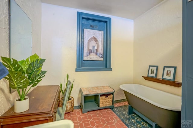 full bath with a freestanding tub and tile patterned flooring