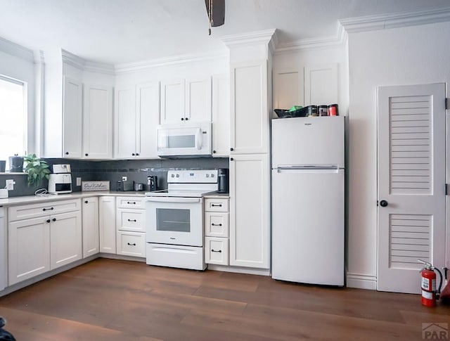 kitchen with crown molding, light countertops, white appliances, white cabinetry, and dark wood-style flooring