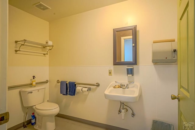 bathroom featuring toilet, visible vents, and a sink