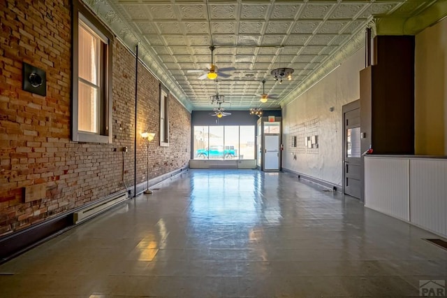 interior space featuring visible vents, an ornate ceiling, brick wall, and a ceiling fan