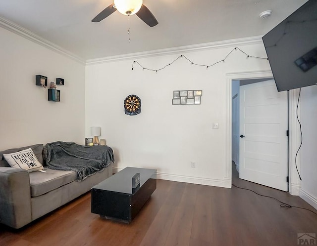 living area featuring crown molding, wood finished floors, a ceiling fan, and baseboards