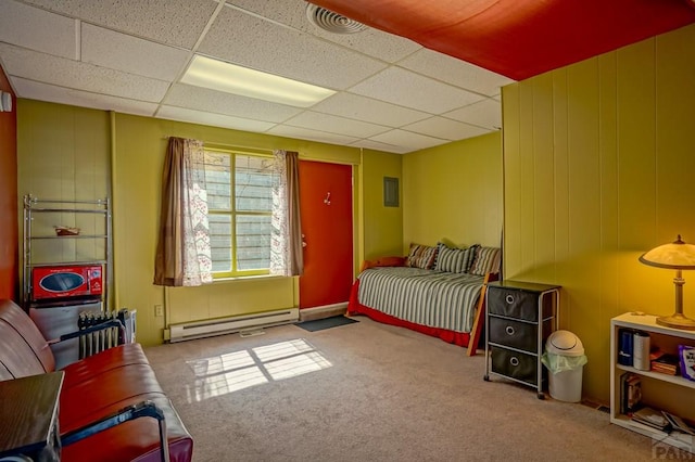 bedroom with visible vents, a baseboard heating unit, carpet, wood walls, and a paneled ceiling