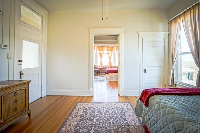 bedroom with light wood-type flooring and baseboards