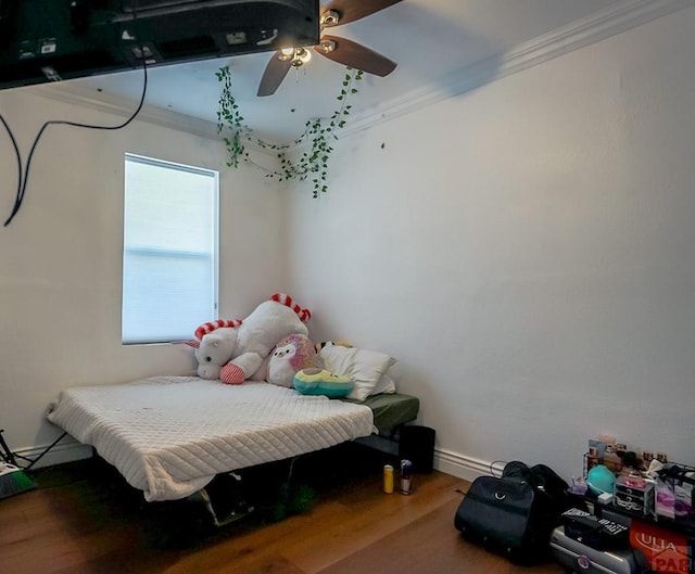 bedroom with ornamental molding, ceiling fan, baseboards, and wood finished floors