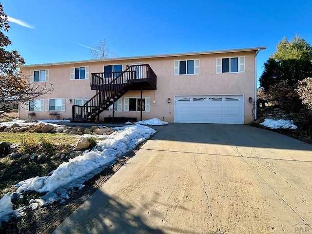 view of front of house featuring a garage, stairs, concrete driveway, and stucco siding