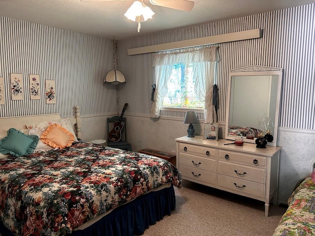 bedroom featuring light carpet, a textured ceiling, and wallpapered walls