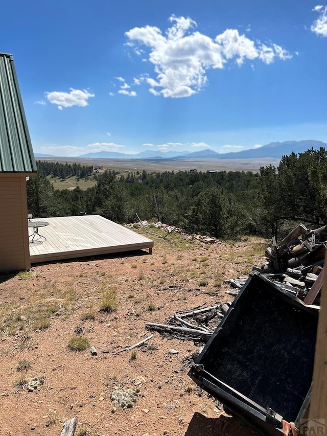 view of yard with a deck with mountain view