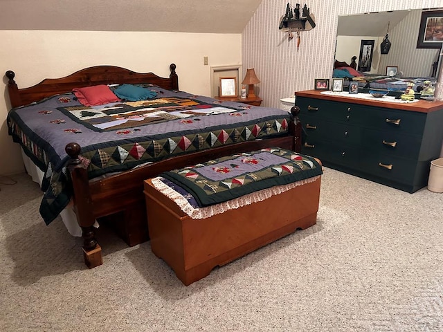 bedroom with wallpapered walls and light colored carpet