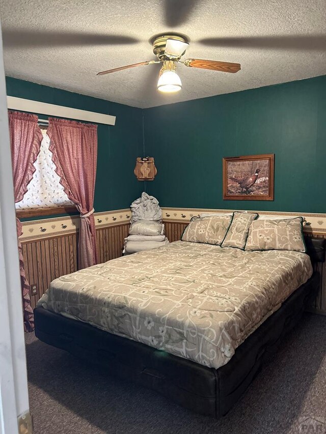 bedroom with radiator heating unit, a ceiling fan, a textured ceiling, and carpet flooring