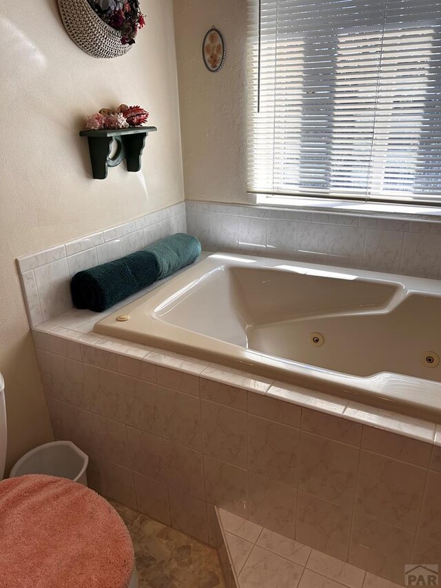 full bath featuring a whirlpool tub and tile patterned flooring