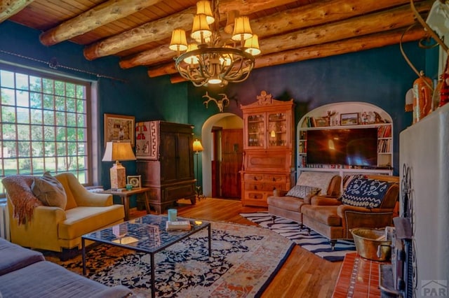 living area with arched walkways, an inviting chandelier, wood ceiling, wood finished floors, and beamed ceiling