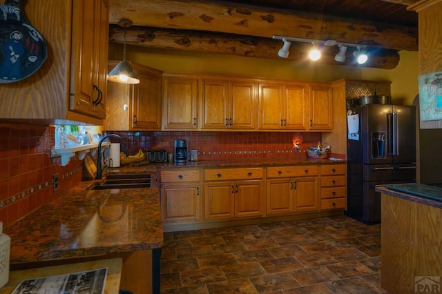 kitchen with decorative backsplash, high quality fridge, hanging light fixtures, and a sink