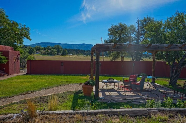 view of yard with a patio area, a fenced backyard, a mountain view, and a pergola