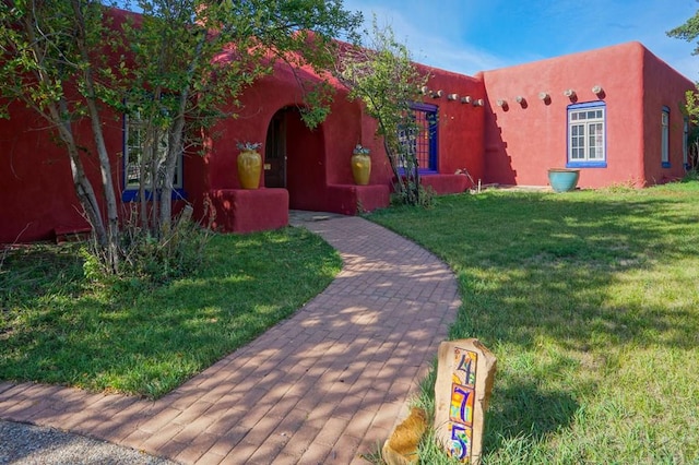 adobe home with a front yard