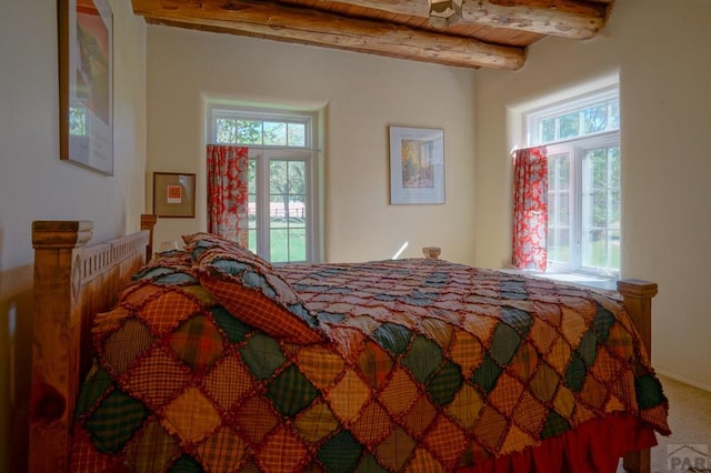 bedroom featuring wood ceiling, multiple windows, and beamed ceiling