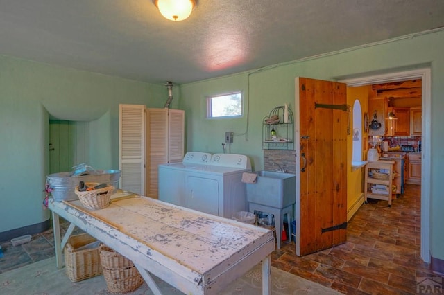 laundry room with laundry area, baseboards, and a sink