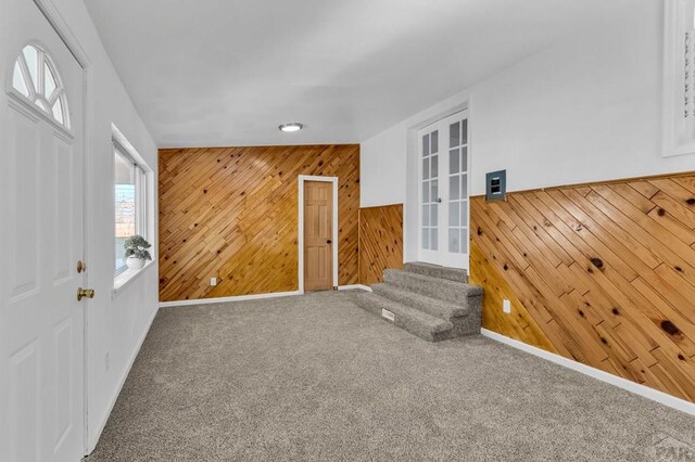 interior space with wood walls, stairs, and baseboards