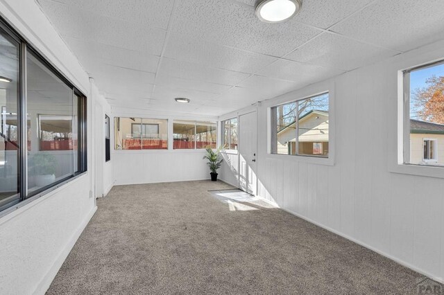 interior space featuring a paneled ceiling and a healthy amount of sunlight