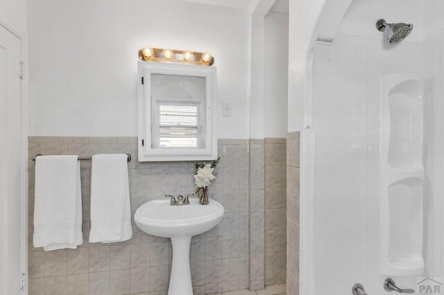 bathroom featuring wainscoting and tile walls