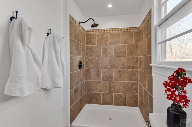 bathroom with toilet and a tile shower