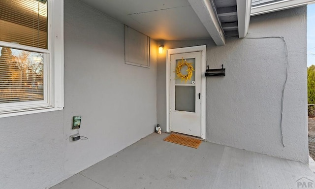 doorway to property featuring stucco siding