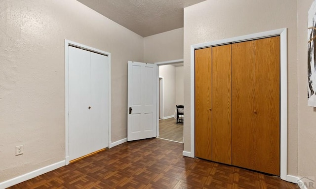 unfurnished bedroom featuring baseboards and a textured ceiling