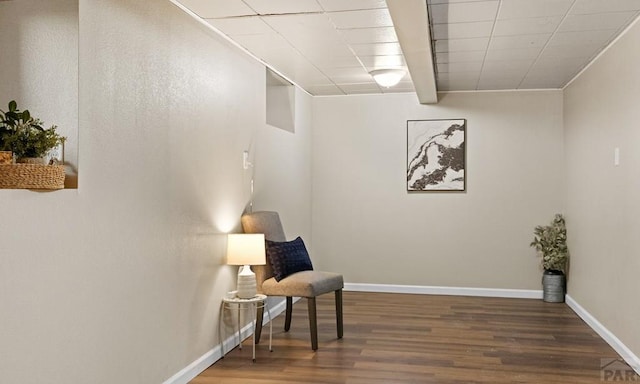 sitting room with baseboards and wood finished floors