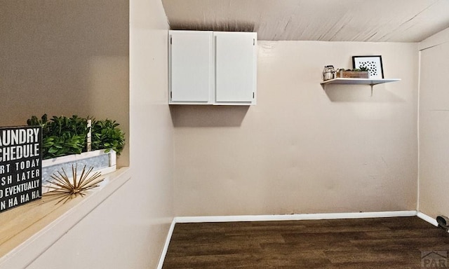 laundry room with baseboards and wood finished floors