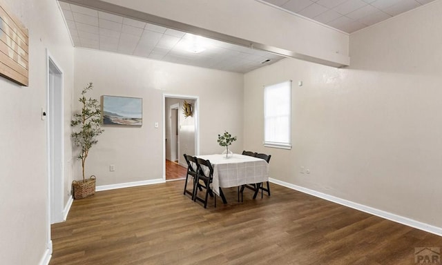 dining space with baseboards and wood finished floors