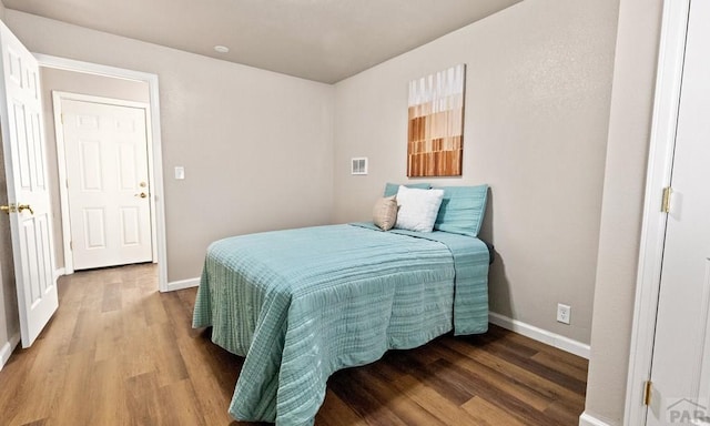 bedroom with wood finished floors and baseboards