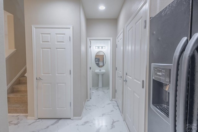 7639 Sandy Springs Pt, Fountain, CO 80817 - hallway featuring light marble finish flooring, baseboards, and a sink