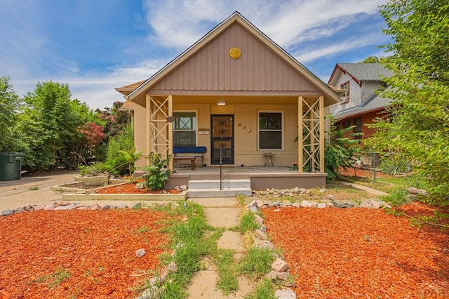 bungalow featuring covered porch and brick siding