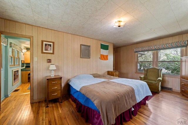 10511 Apache City Rd, Rye, CO 81069 - bedroom featuring wooden walls, hardwood / wood-style floors, and visible vents