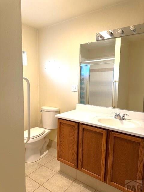 bathroom featuring toilet, a shower stall, vanity, and tile patterned floors