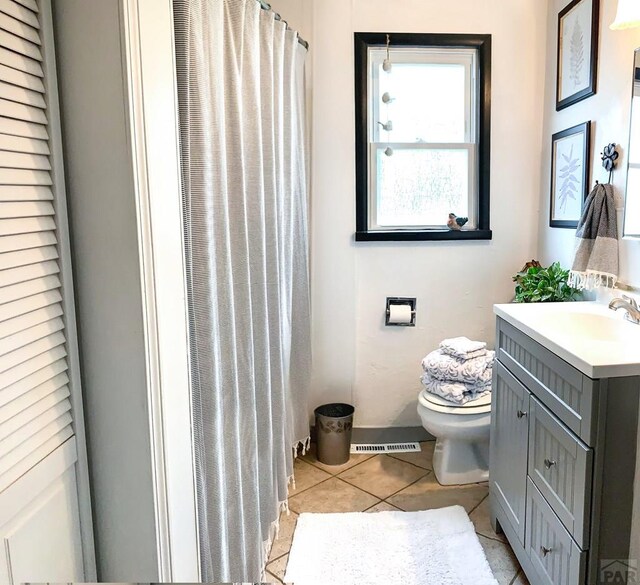 bathroom with a shower with curtain, vanity, toilet, and tile patterned floors