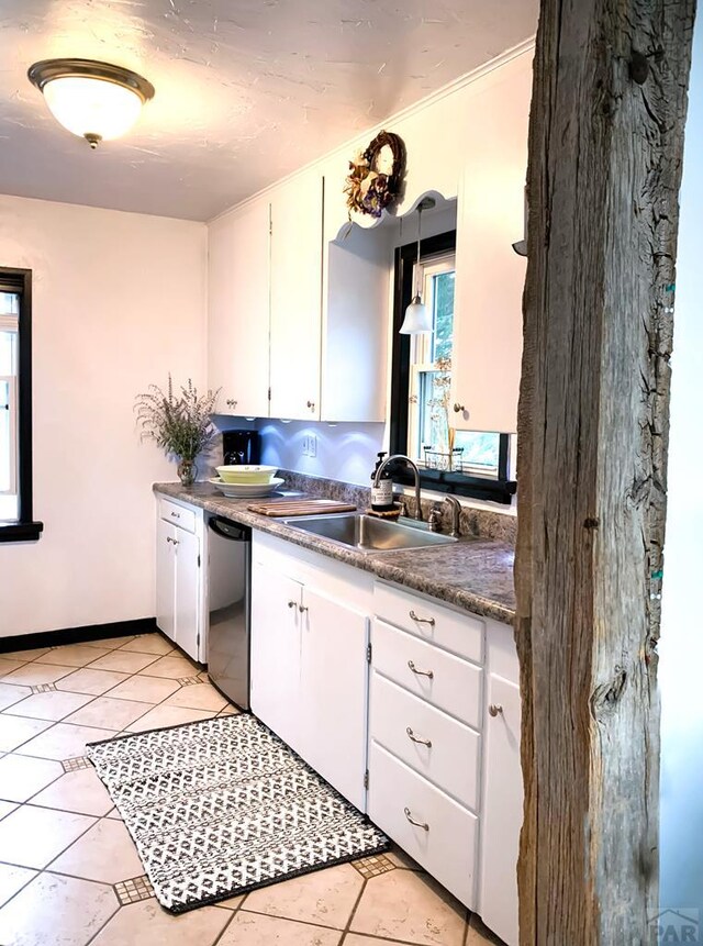 kitchen featuring light tile patterned floors, white cabinets, stainless steel dishwasher, pendant lighting, and a sink