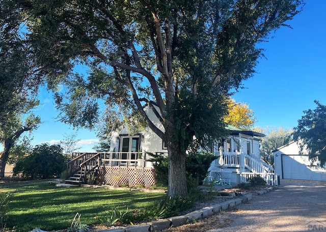 view of front of house with a front lawn and an outbuilding