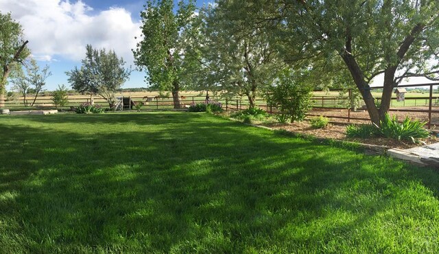 view of yard with a rural view and fence