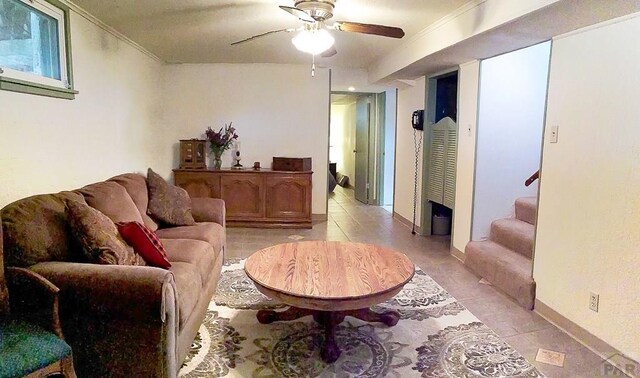 living room featuring light tile patterned floors, a ceiling fan, stairway, and crown molding